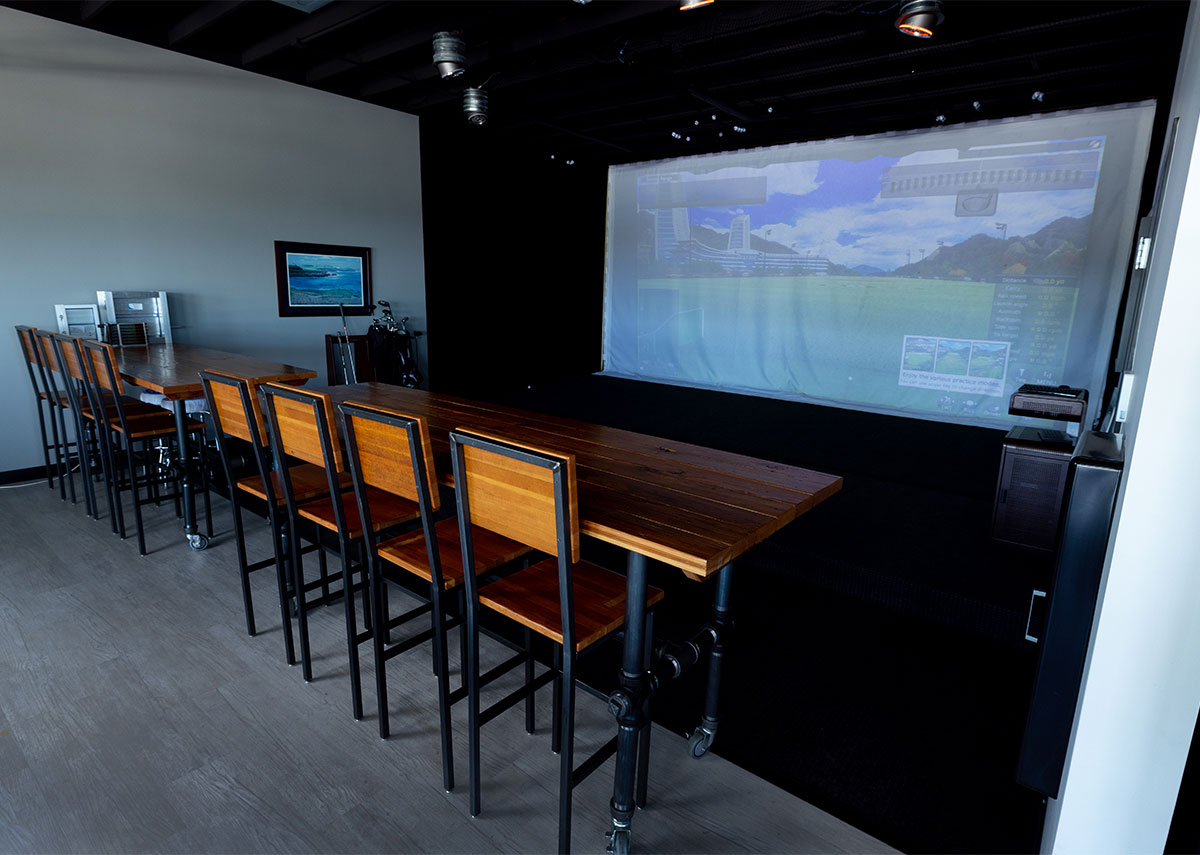 Setpoint Mechanical fun room with screen for indoor golf and bar table