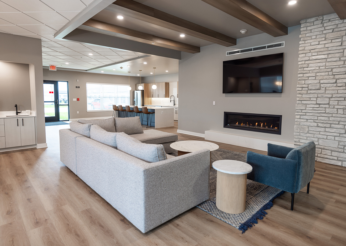 Stratford Pointe Apartments common area with couch fireplace leading into kitchen area