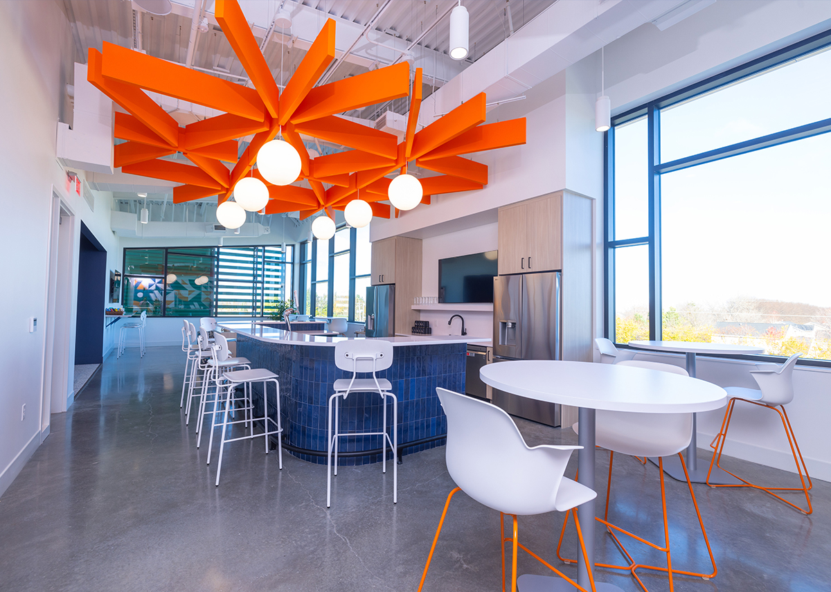 Vibrant Insurance kitchen area with large orange beams