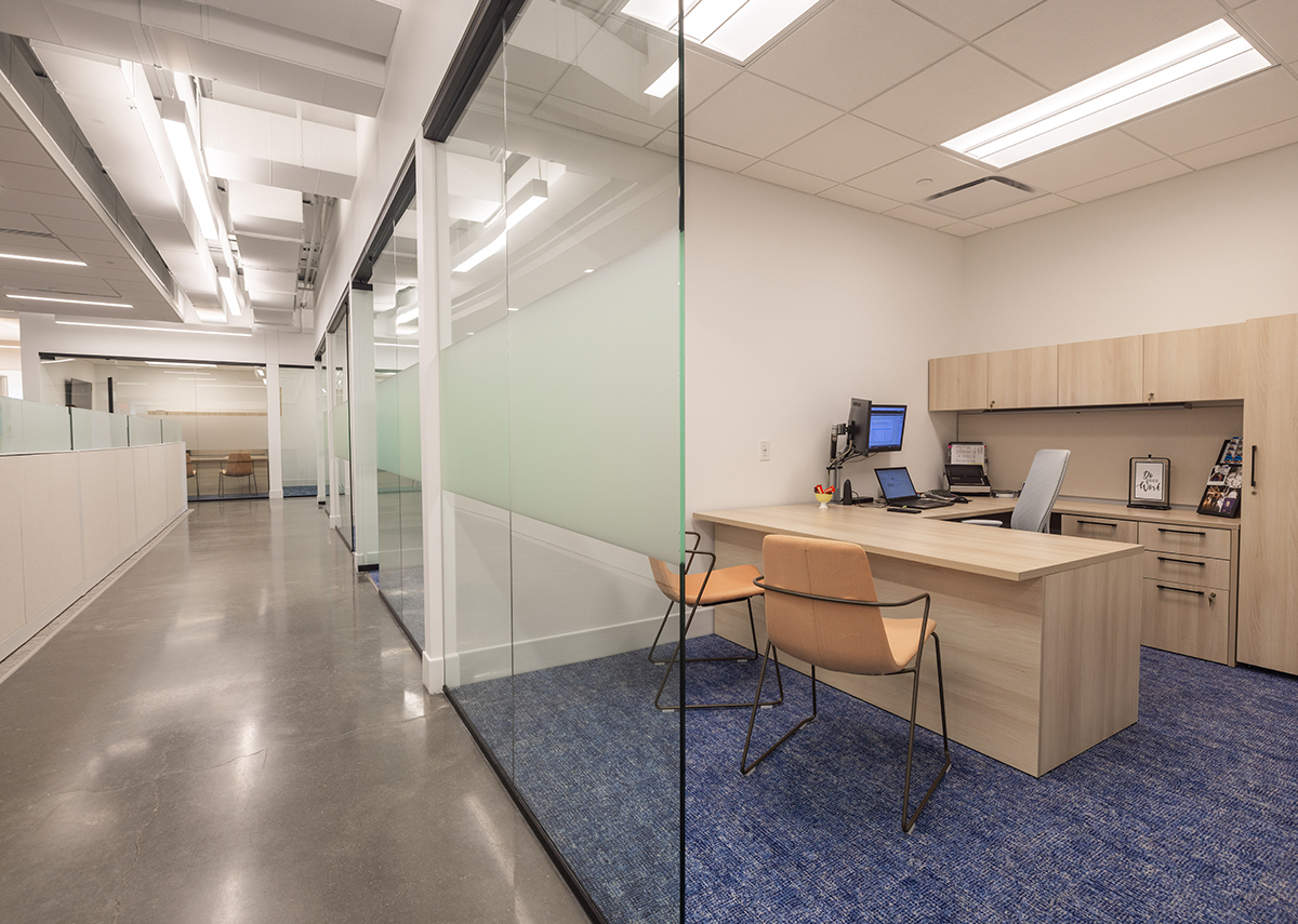 Vibrant Insurance hallway inside office with desk and chairs